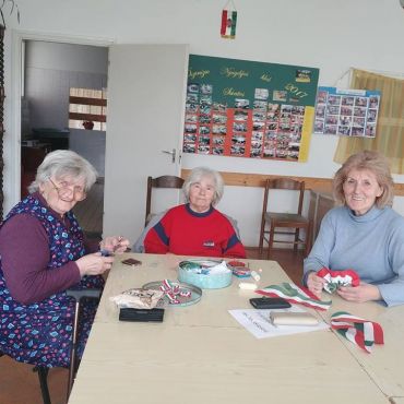 Készülődés a nemzeti ünnepre A kokárda készítés inkább női kezeket igényel, többen készítik elő az ünnepekre valót.