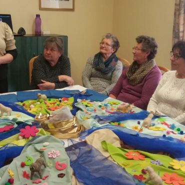 Érdeklődő tekintetek. Az asztal körül ülő klubtagok érdeklődéssel hallgatják a mesélőt.