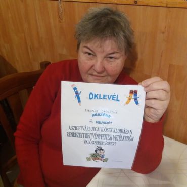 Az elismerő oklevél klubtagunk kezében. A klubtagunk elégedetten mutatja oklevelét.