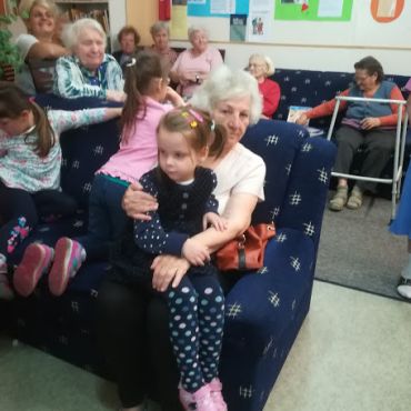 "Olyan, mint a nagyinál..." Az idős hölgy ölében a kislány úgy helyezkedik el, mintha nagyszülője lenne.